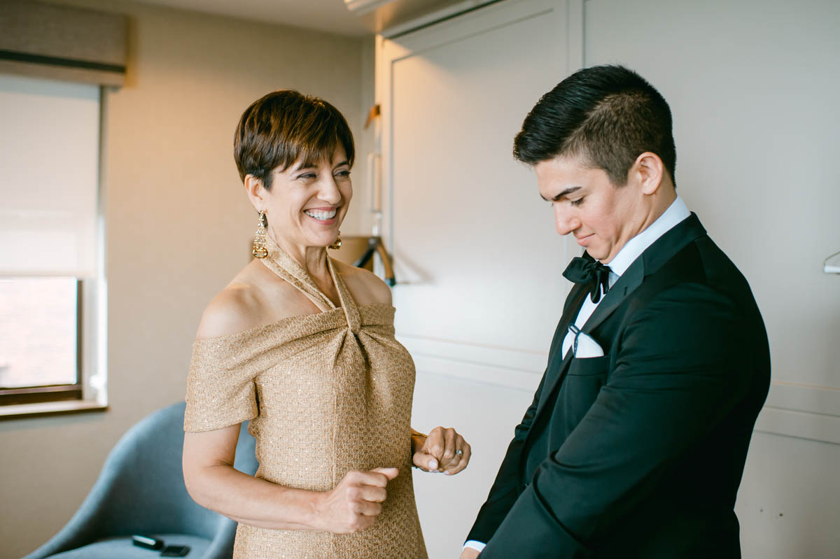 Groom's mom helping him get dressed.