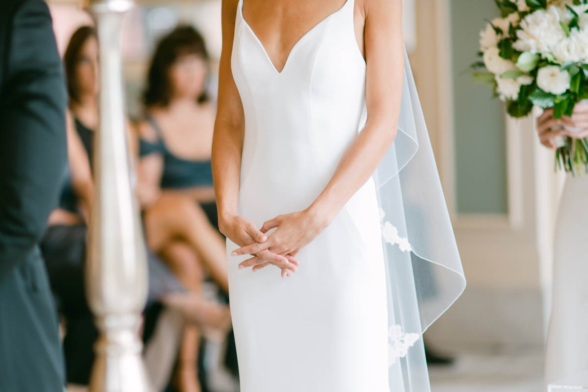 Bride with her hands clasped on her wedding day.