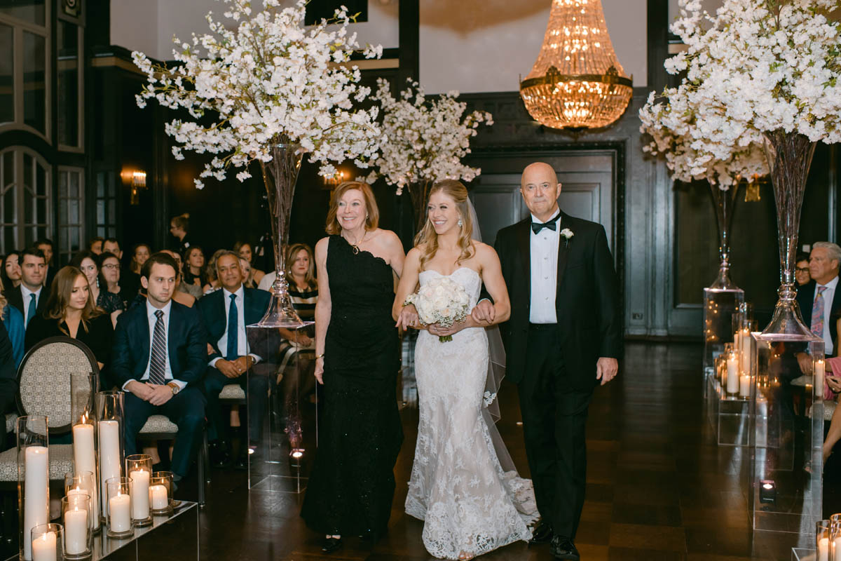 Bride walking down the aisle with her parents.