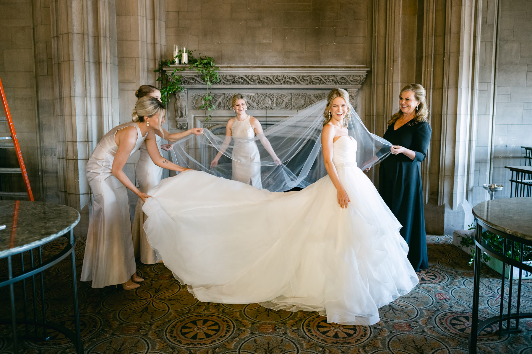 Bridesmaids helping bride into her wedding dress at the University Club of Chicago.