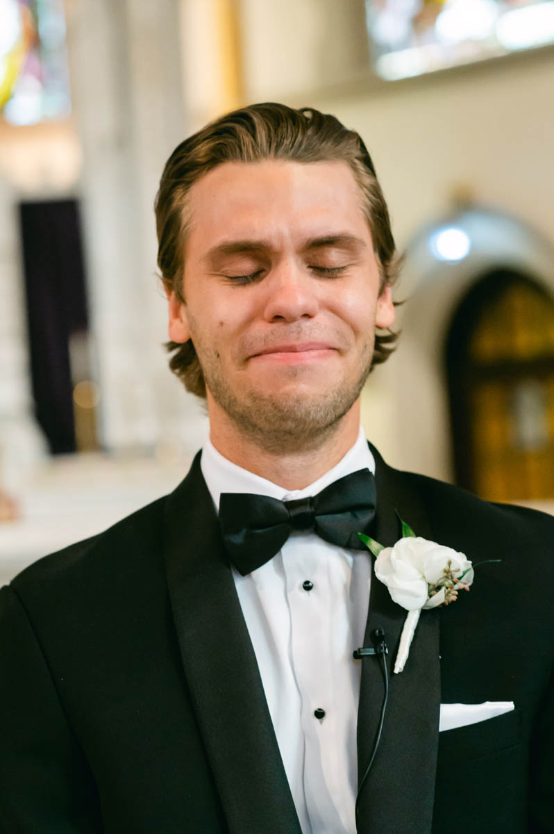 Emotional groom seeing his bride walking down the aisle.