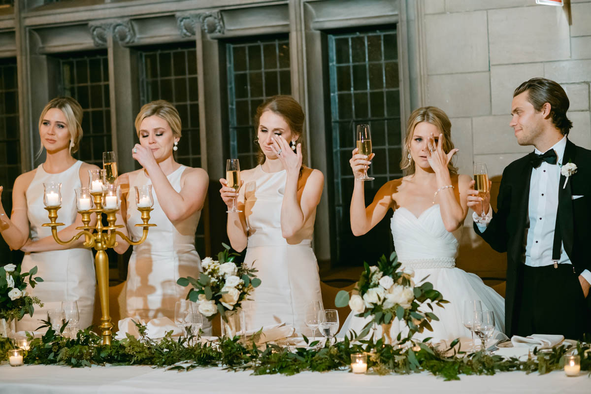 Bridesmaids tear up during wedding toasts.