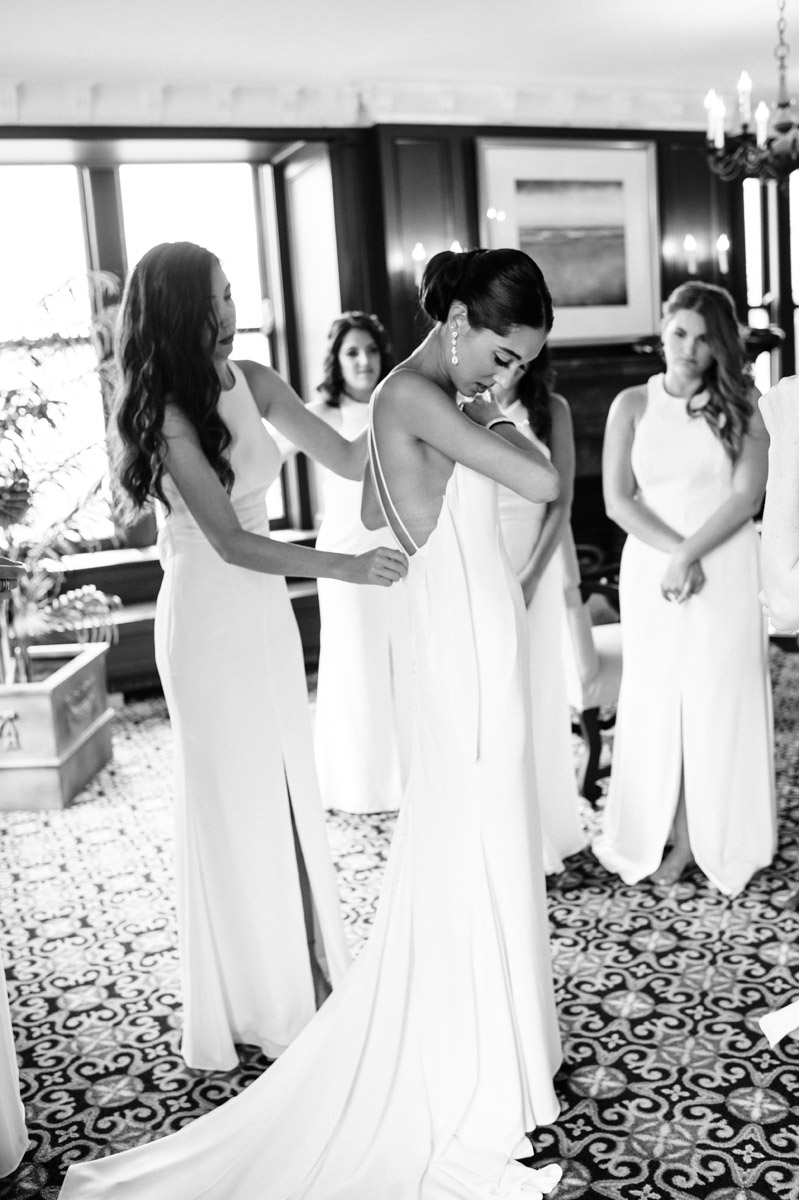 Bridesmaids helping bride get ready.