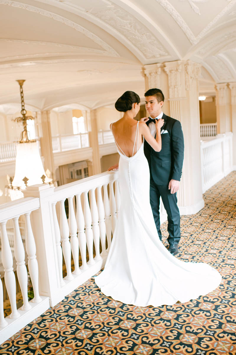 Bride fixing groom's tie at South Shore Cultural Center wedding.