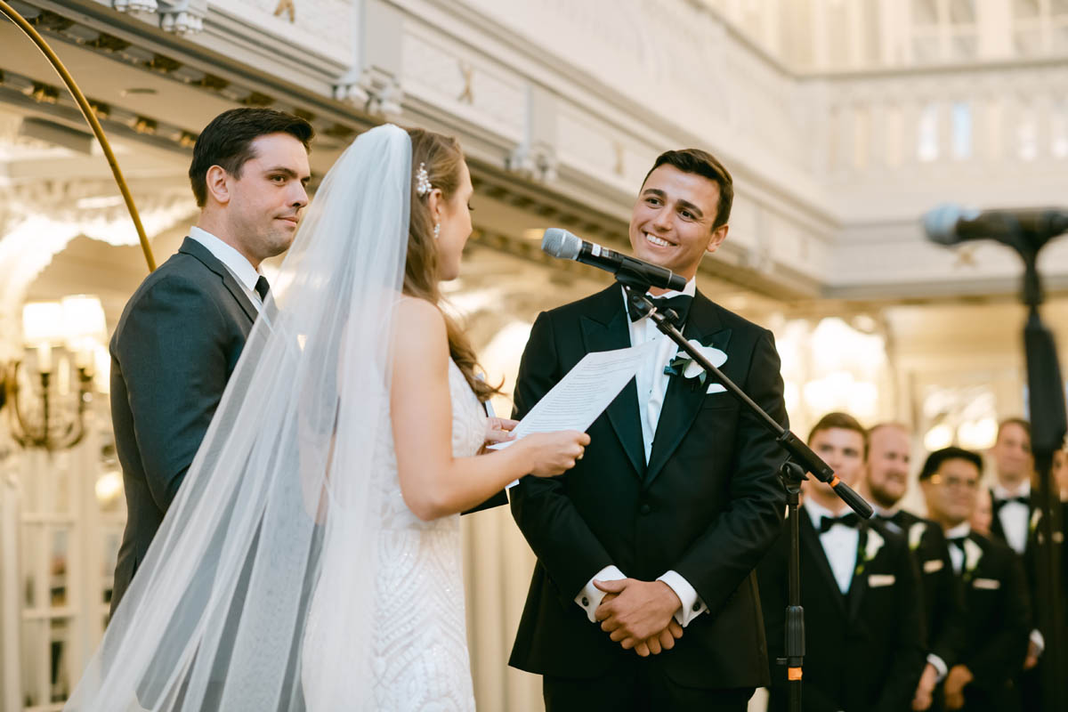 Handsome groom smiles at his bride during ceremony.