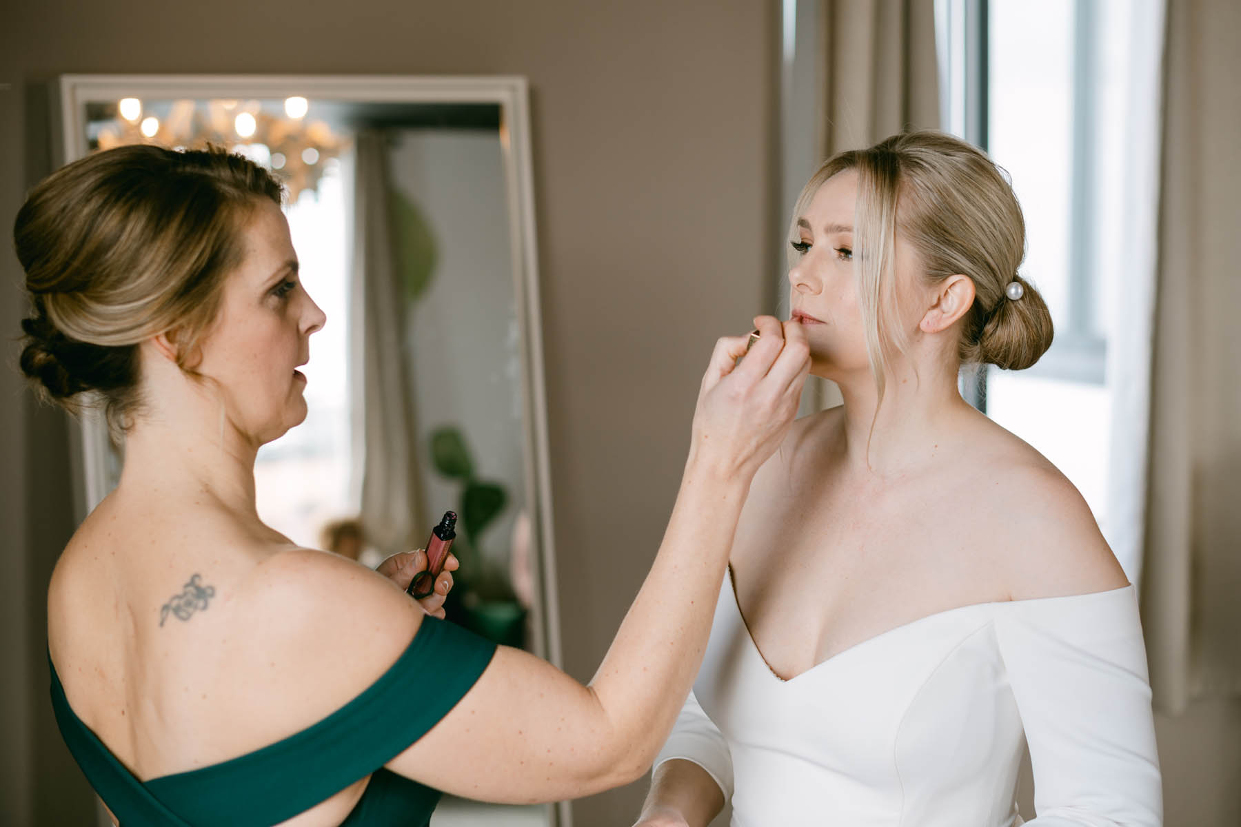Bride's sister putting on her lipstick.