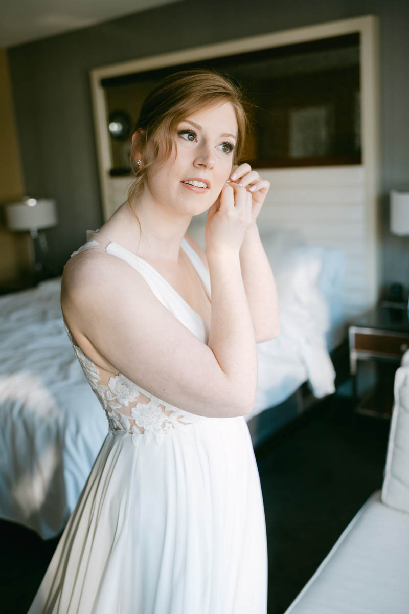 Bride putting earrings on.