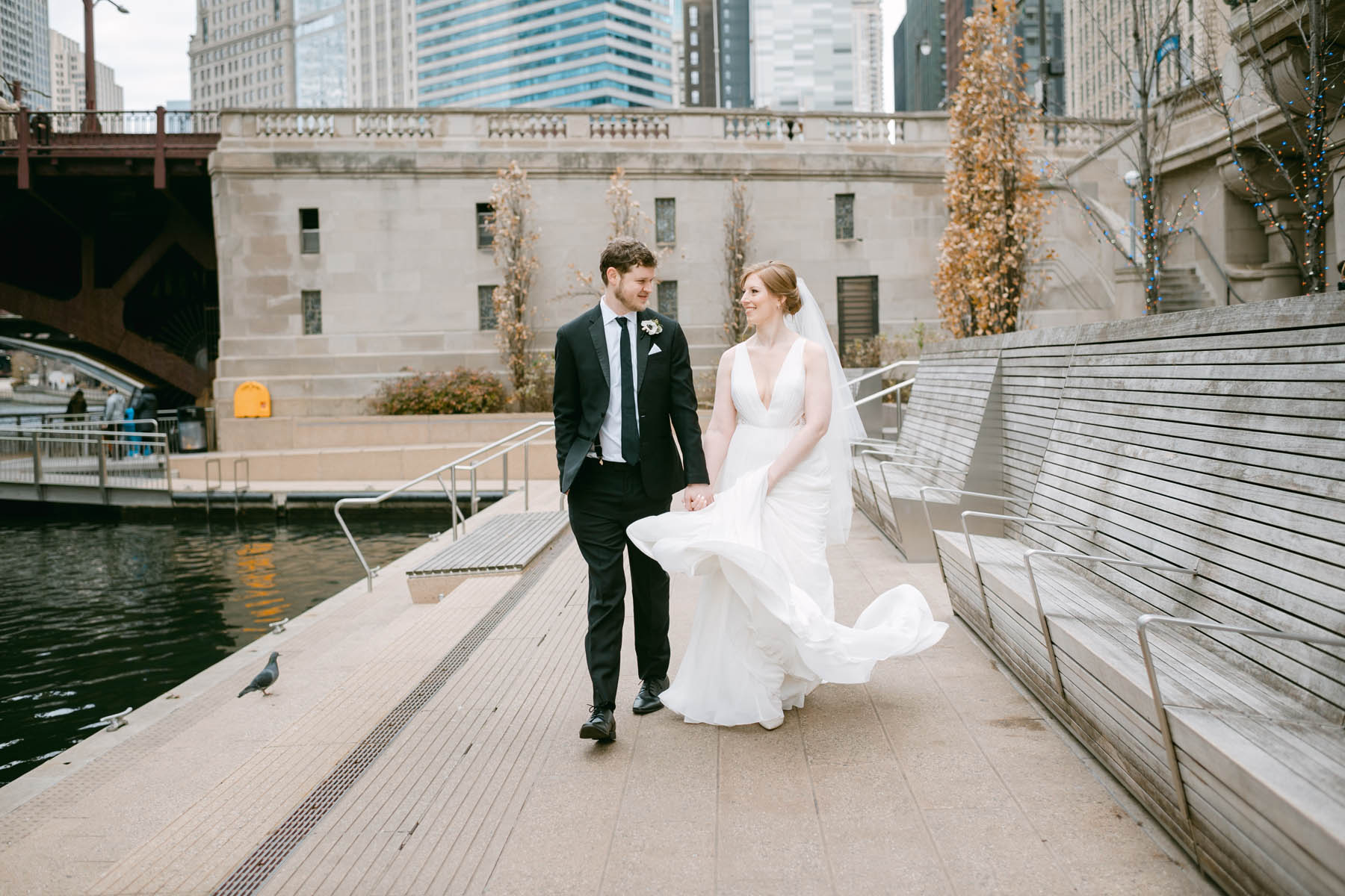 Wedding couple walk along the Chicago Riverwalk.