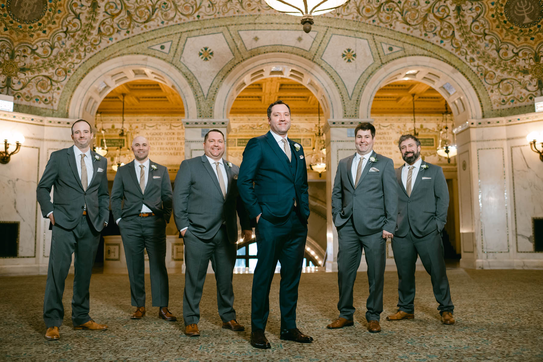 Groomsmen taking photos at the Chicago Cultural Center.