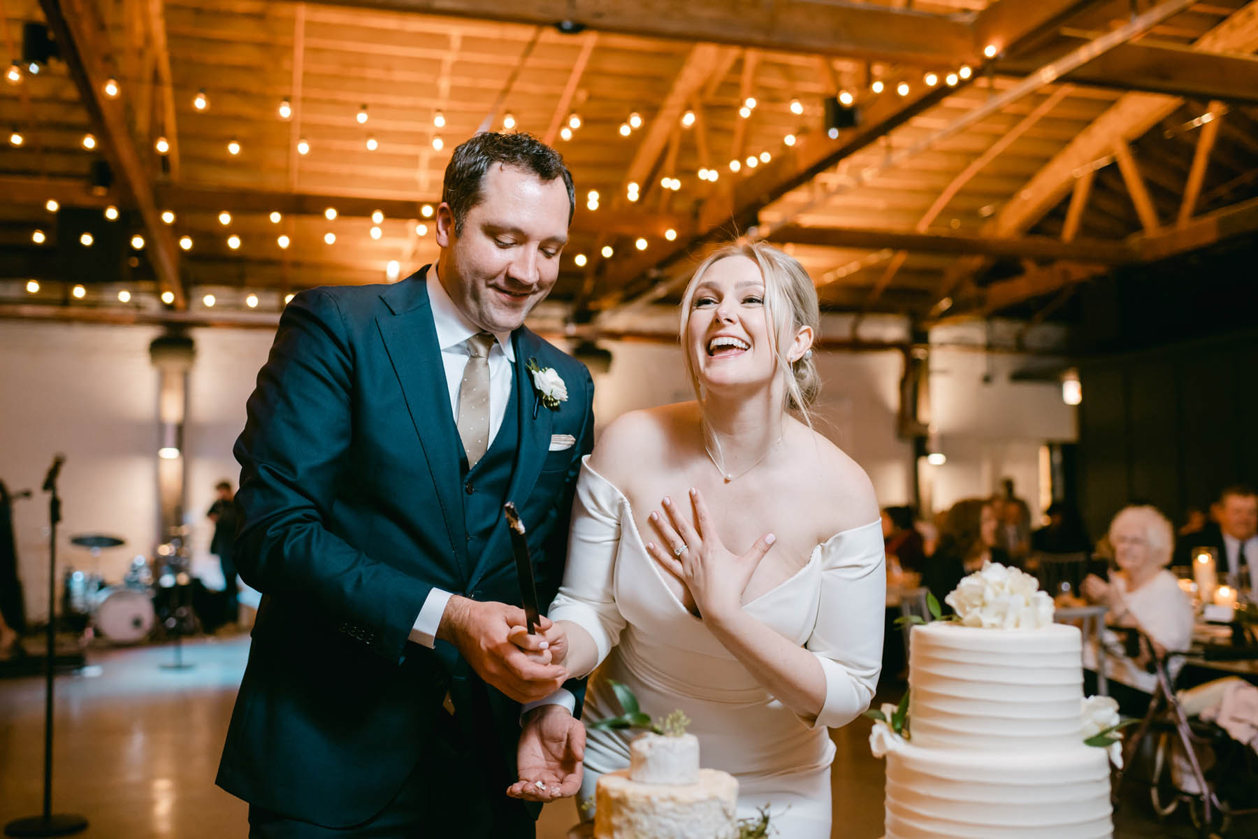 Laughing bride and groom cutting the cake