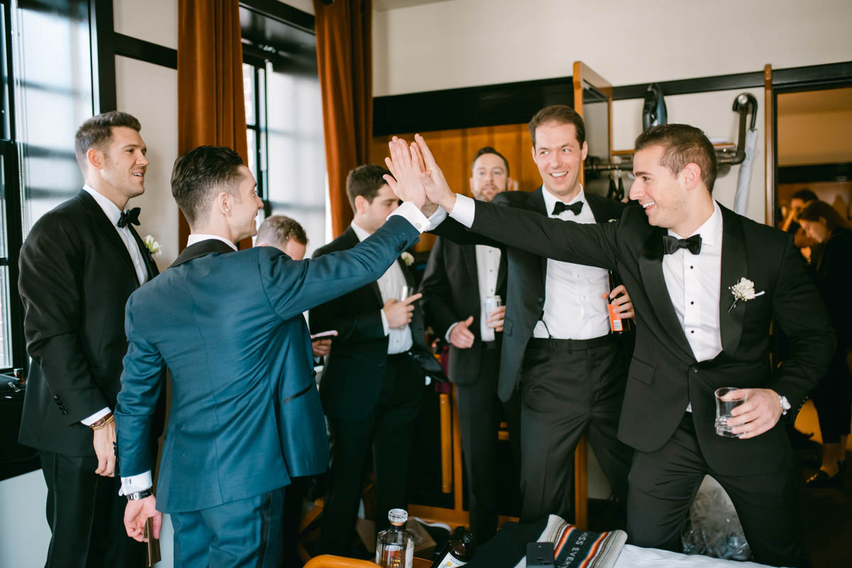Groomsmen high five with groom.
