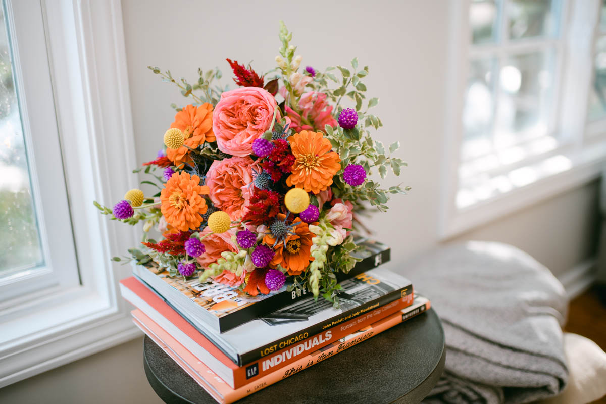 Bright wedding flowers sit on table.