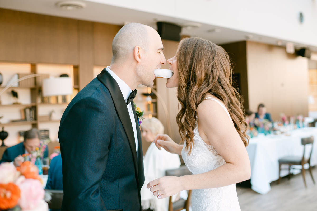 Wedding couple bits donut at their Gibsons Italia wedding.