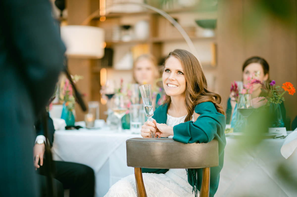 Bride smiling at wedding toasts.