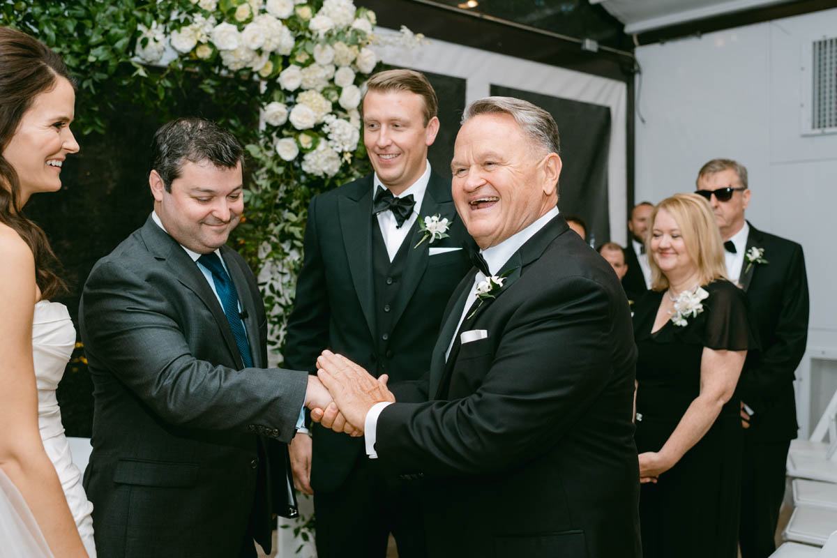 Father of the bride laughing at wedding ceremony.