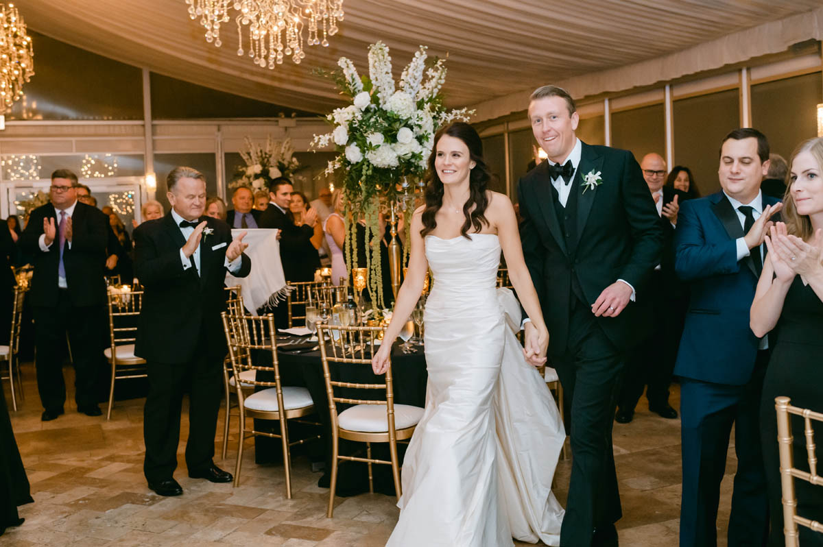 Bride and groom walking into reception.