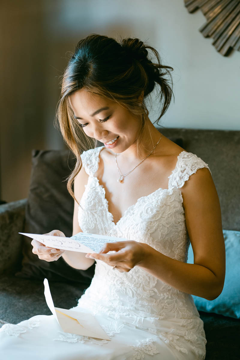 Bride reading letter from groom on her wedding day.