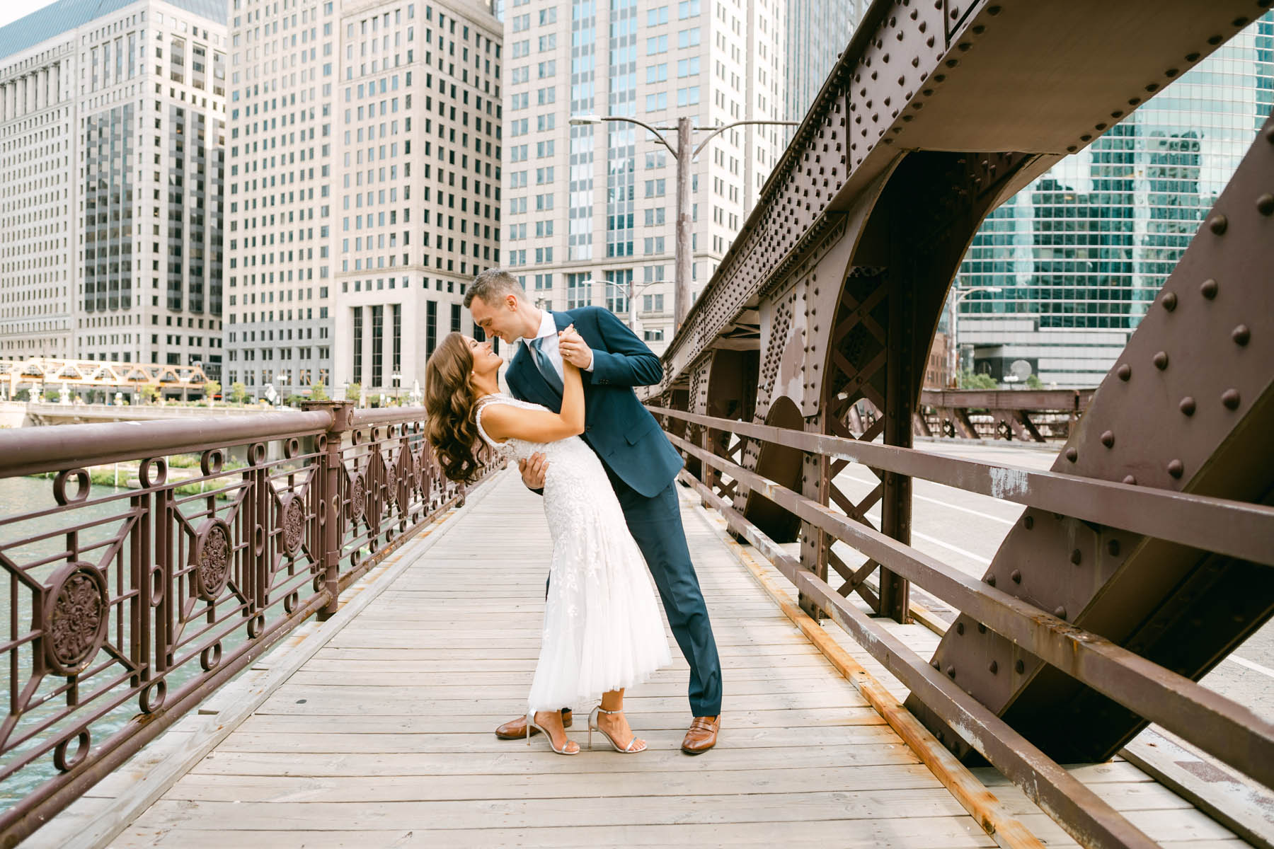 Wedding couple posing for photos on the Chicago Riverwalk bridge.