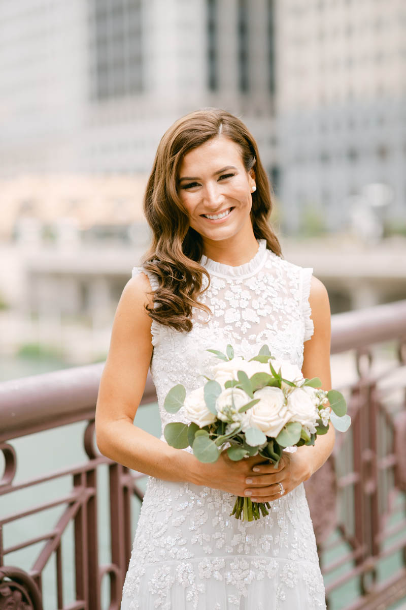 Bride holding white wedding bouquet.