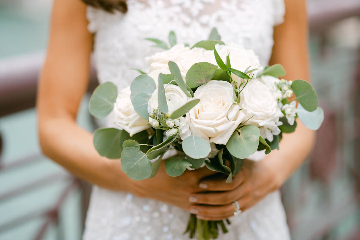 Bride holding white wedding bouquet.