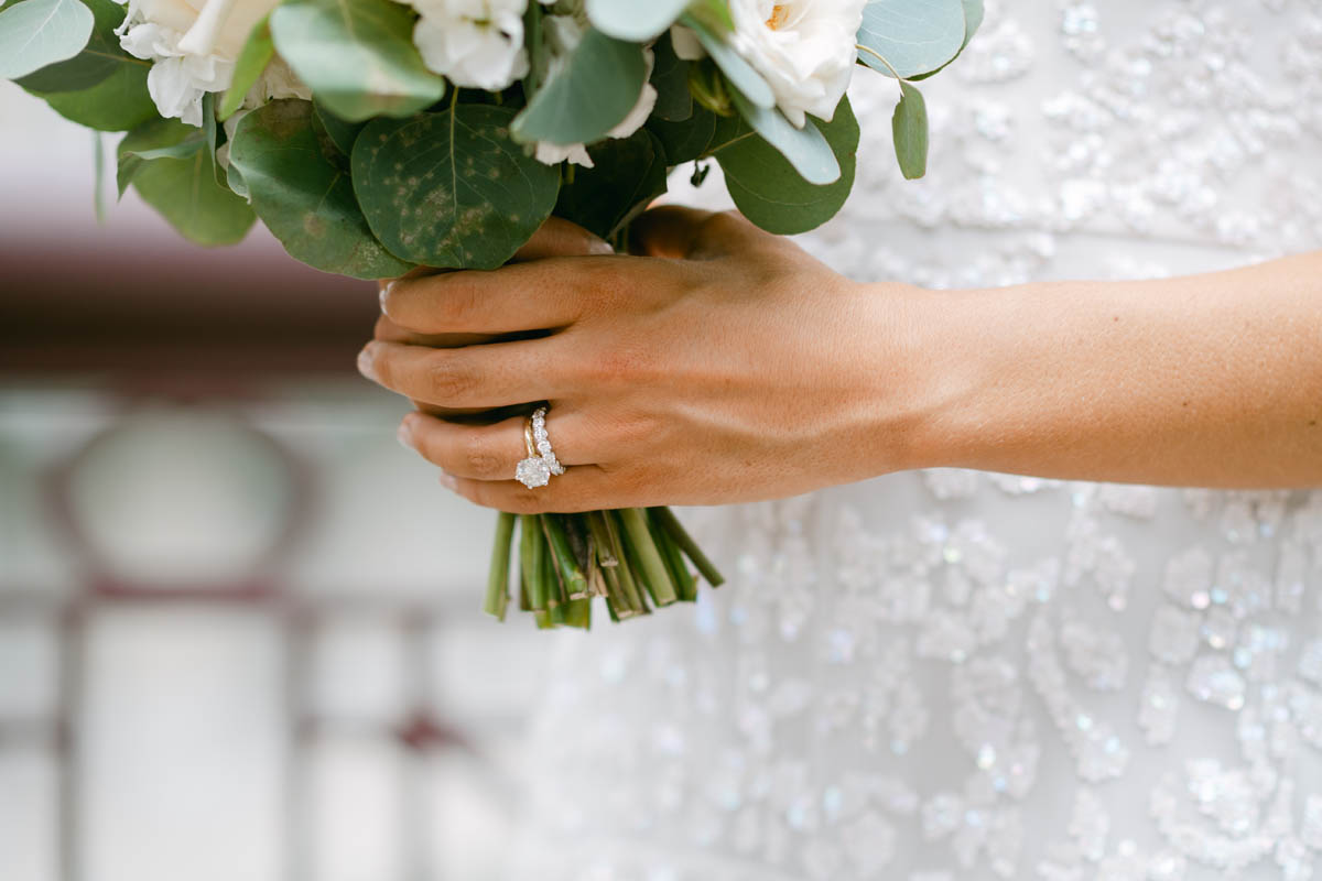 Bride holding white wedding bouquet.