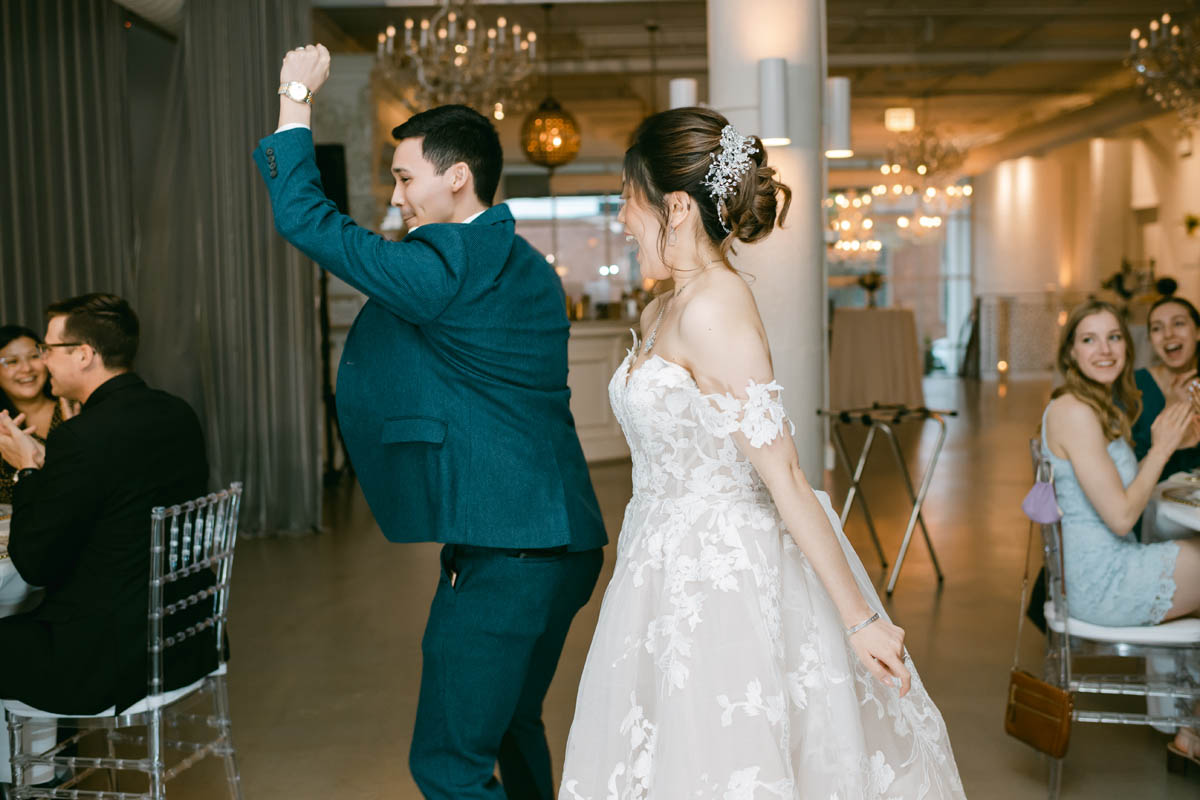 Bride and groom celebrate as they walk into reception.
