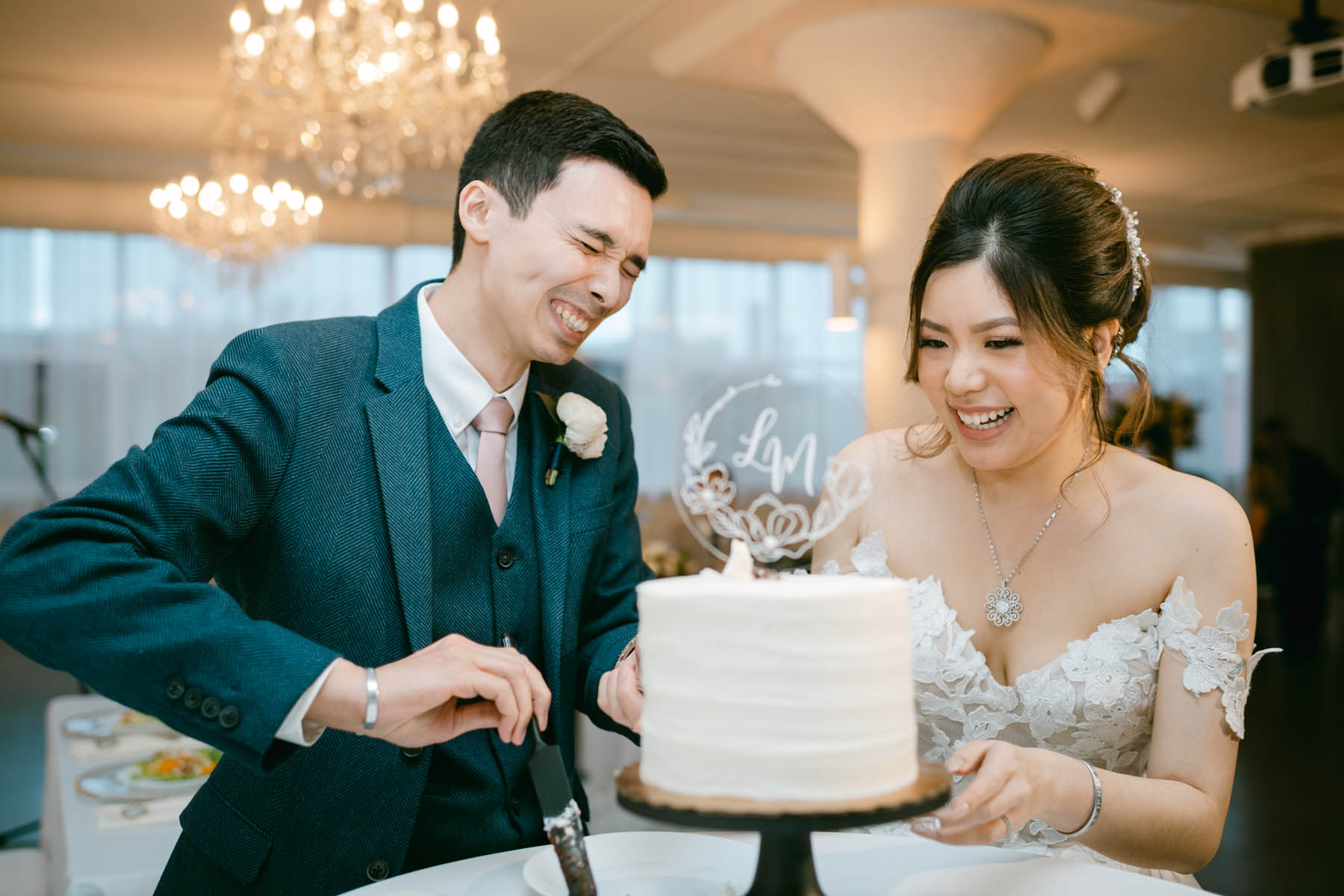 Groom laughs as he cuts wedding cake at Room 1520.