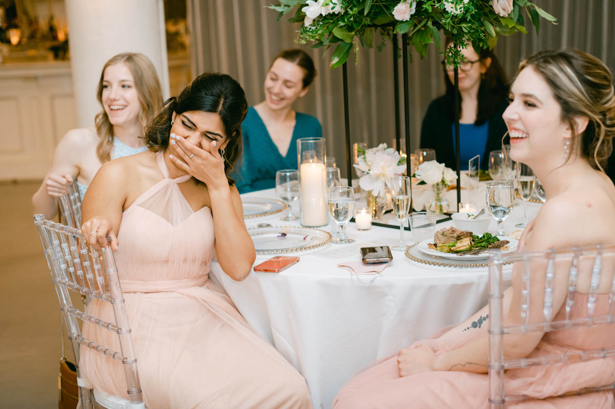 Wedding guests laugh during wedding toasts.