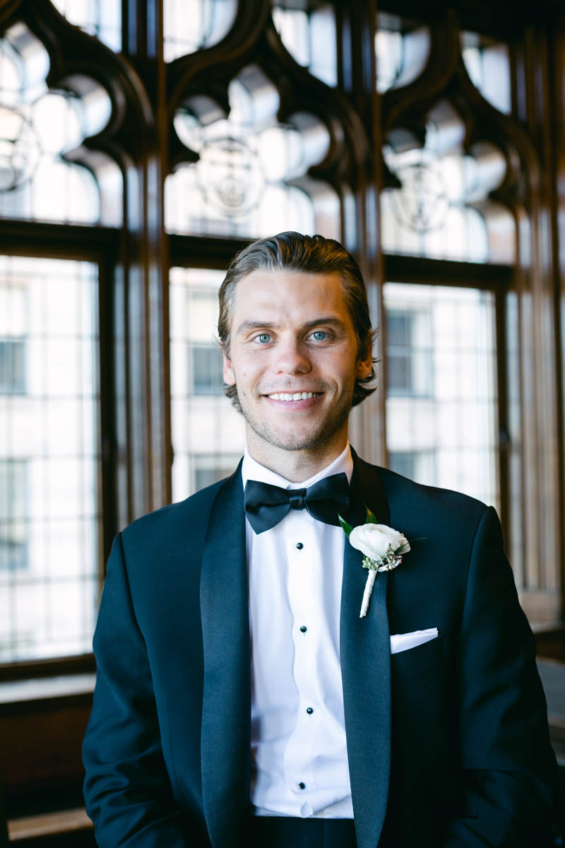 Handsome groom poses for wedding photos.