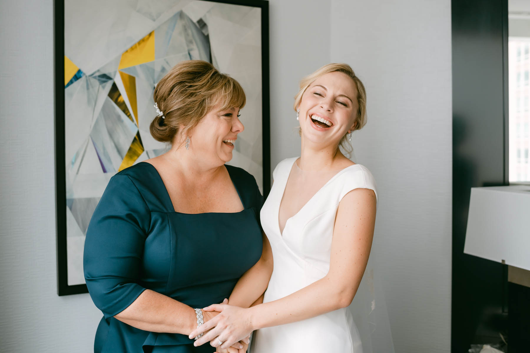 Bride laughing with her mom on her wedding day.
