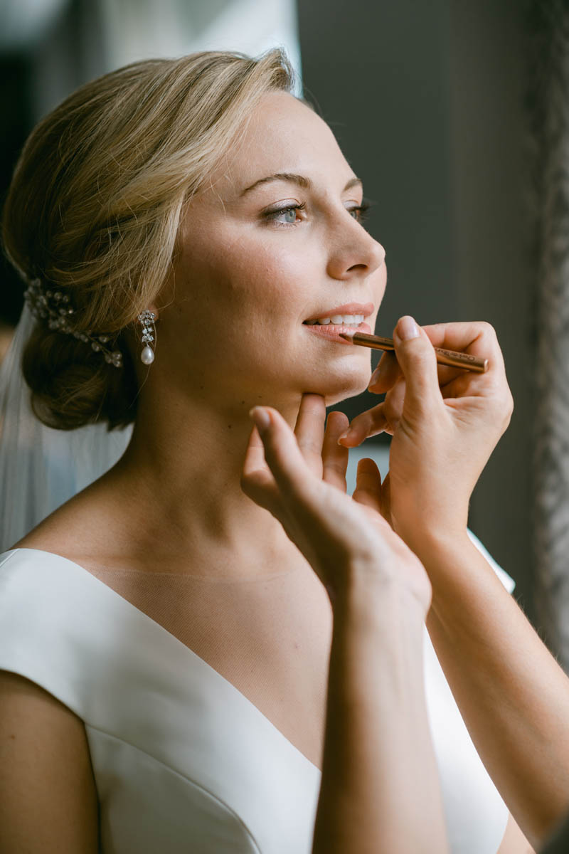 Bride getting her makeup done on her wedding day.