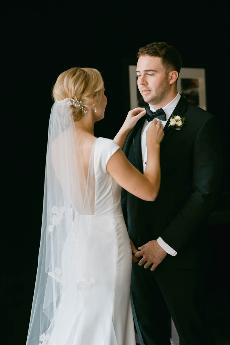 Bride straightening the tie of her groom.