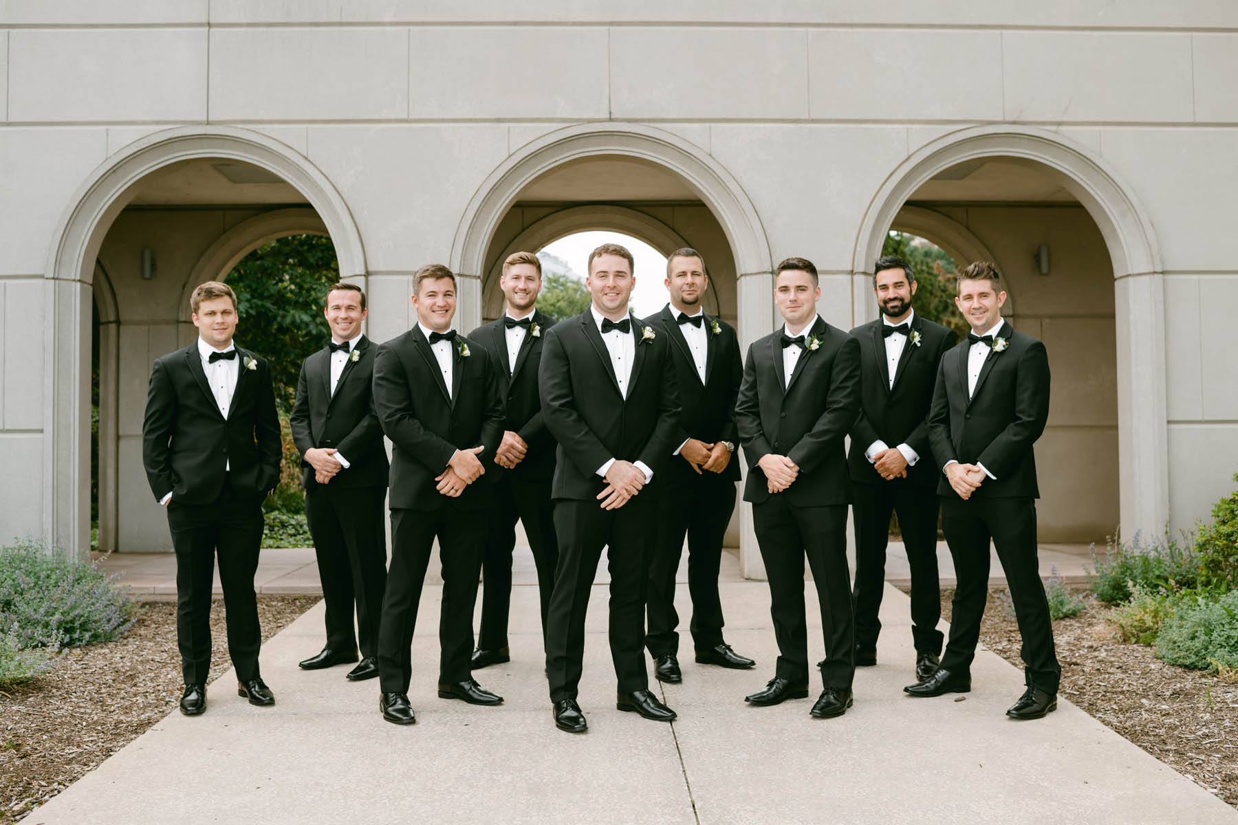 Groomsmen pose for photos at Loyola.