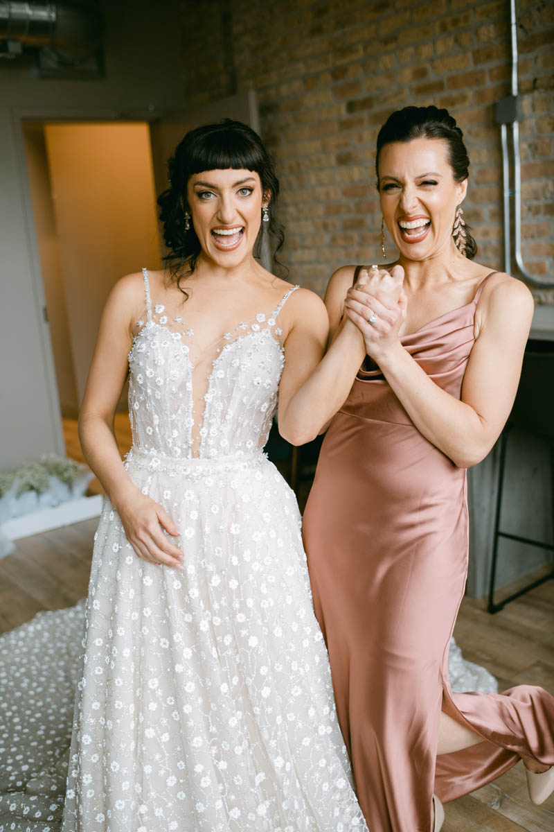 Bride laughing with her sister.