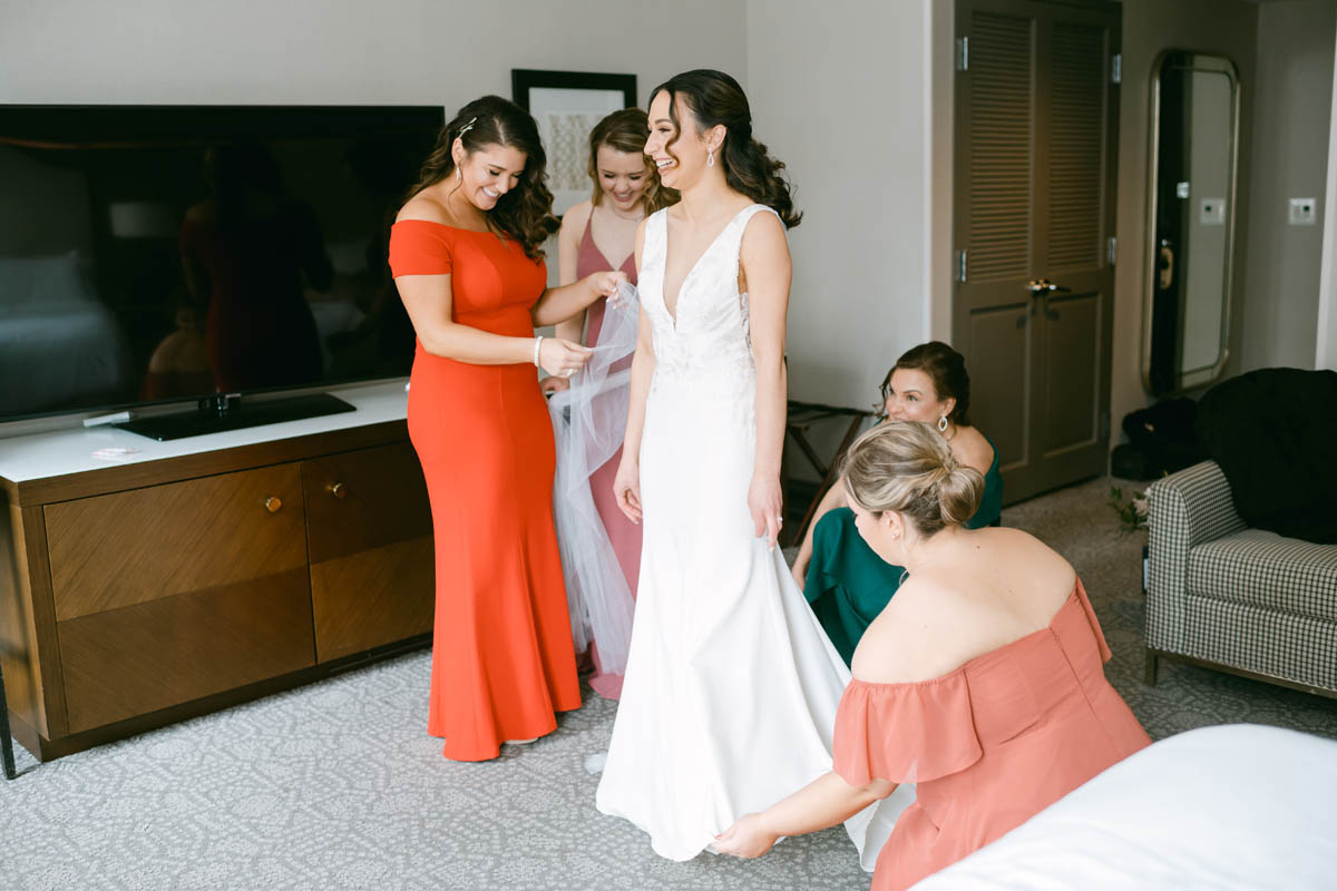 Bridesmaids helping bride get ready.