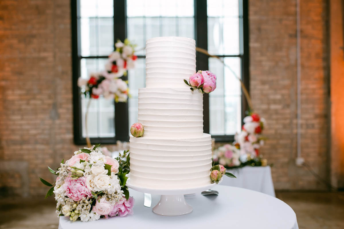 White wedding cake with pink flowers.