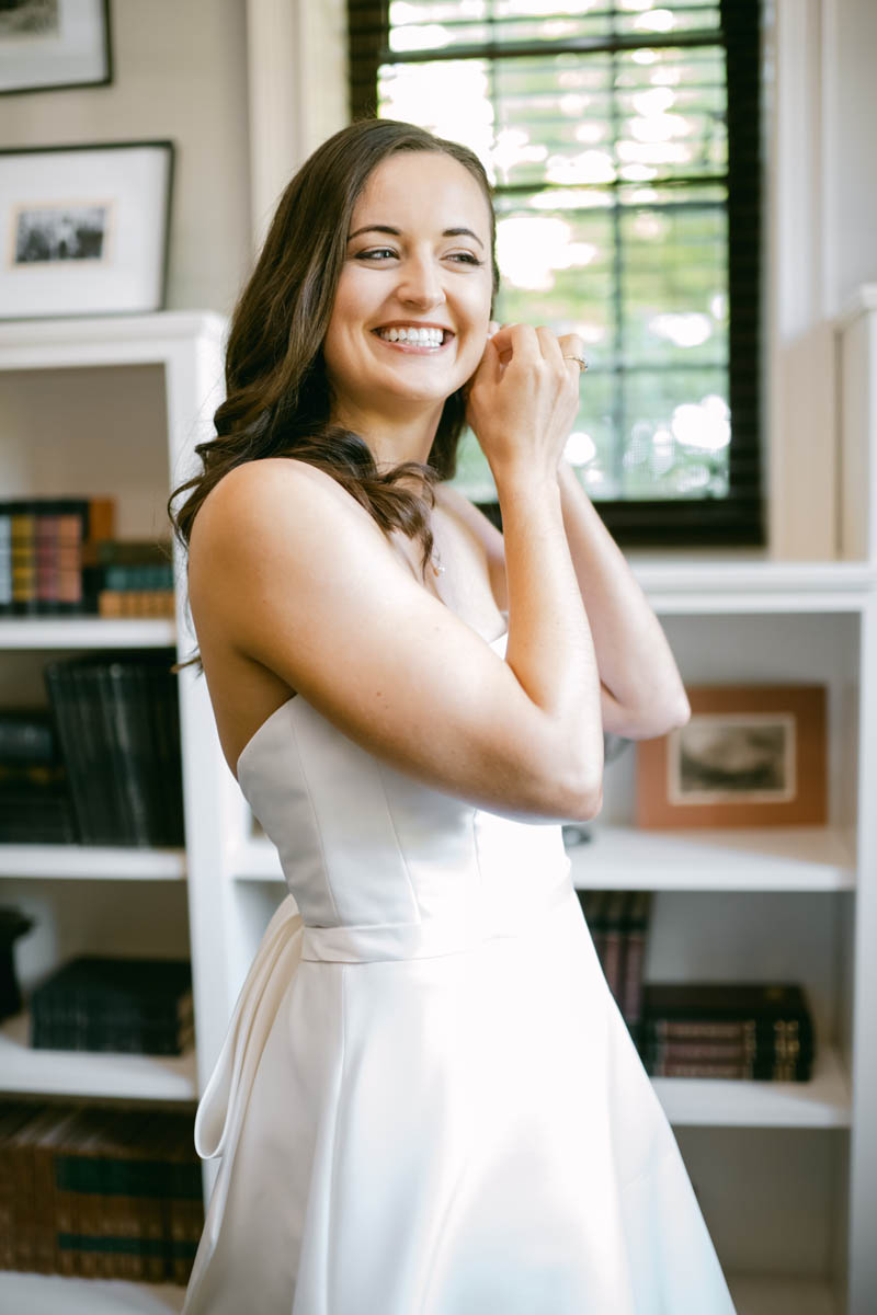 Bride putting earrings on