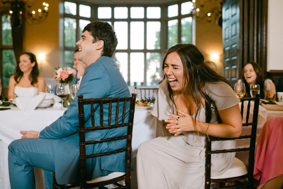 Bridesmaid laughing at wedding toasts