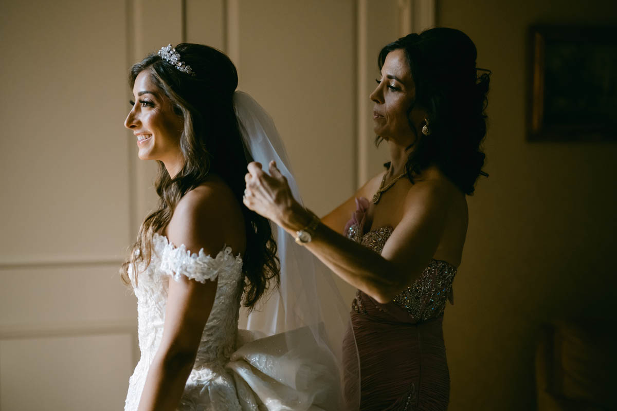 mom putting veil on bride