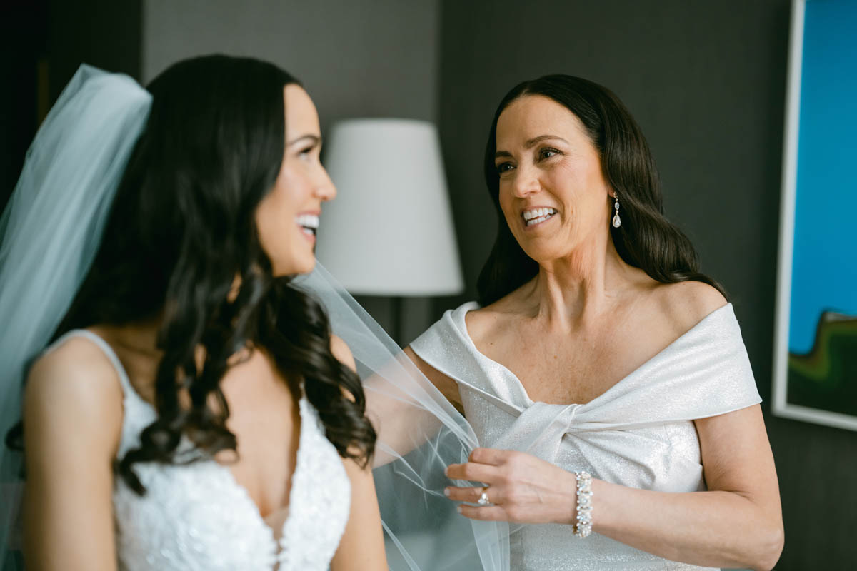 Mom helping bride put on wedding veil