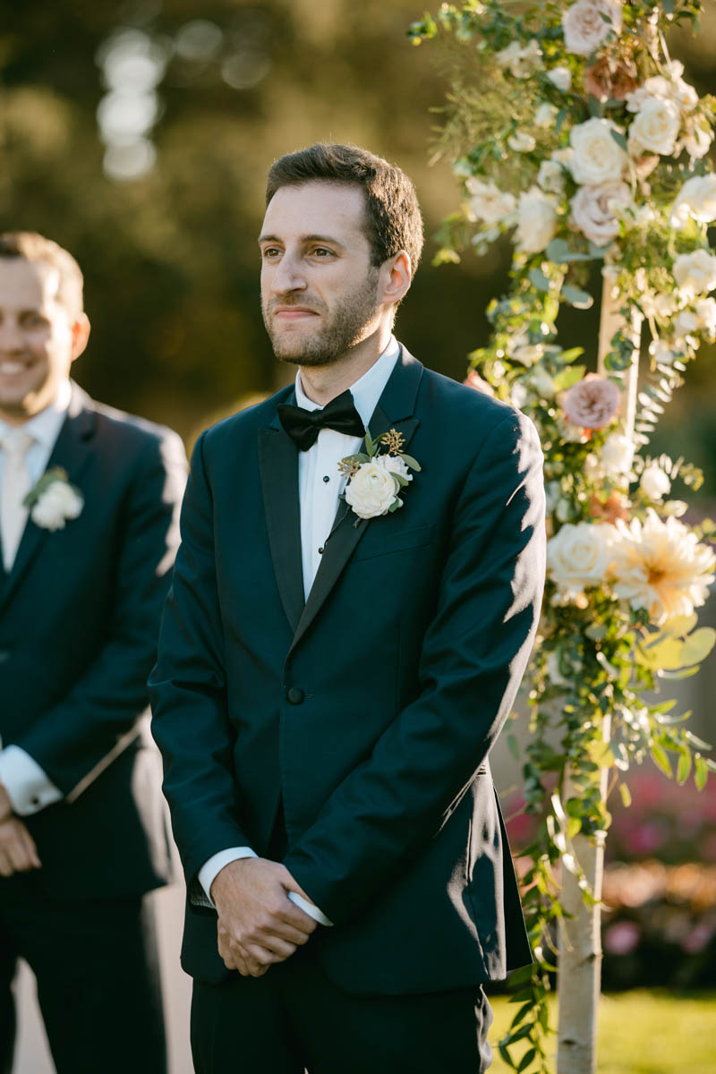 groom watching bride walk down the aisle