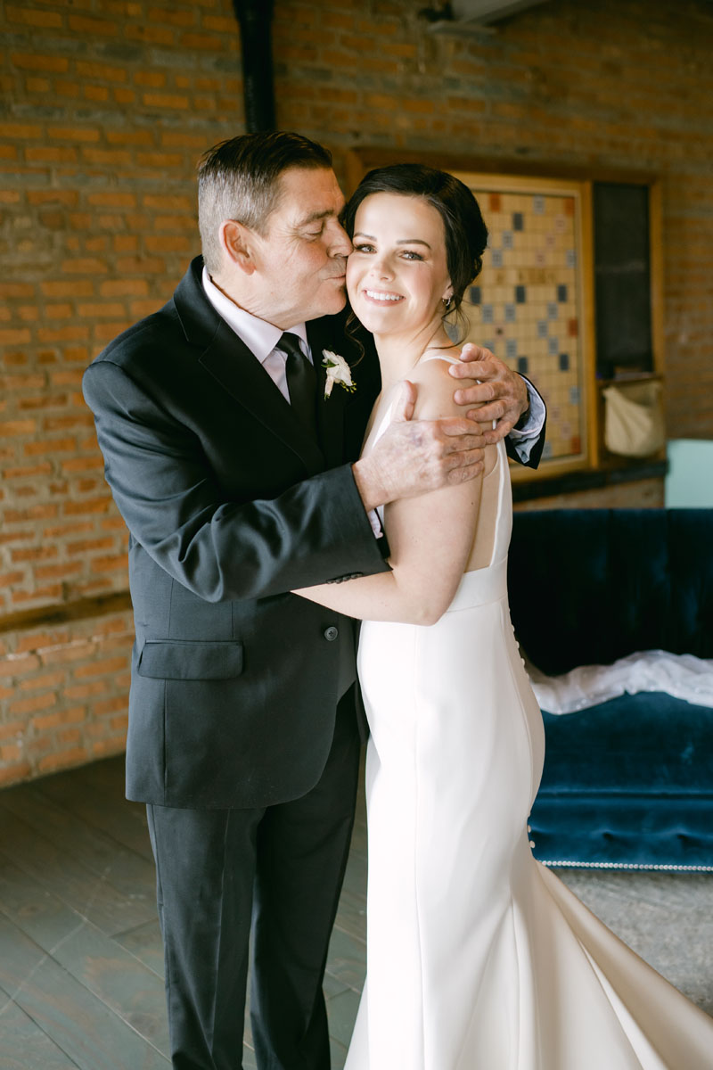father of the bride kissing his daughter