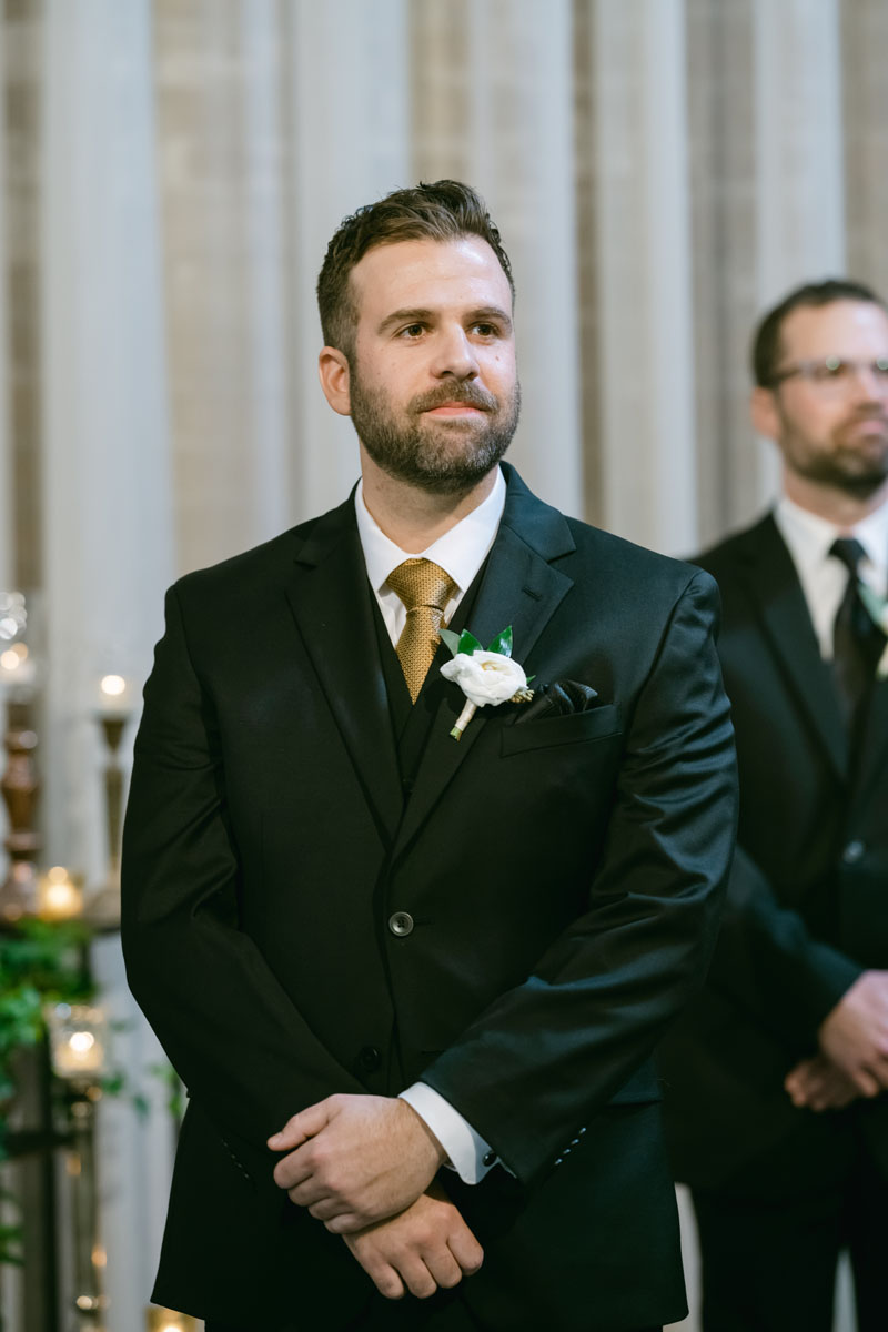 groom watching bride walk down the aisle