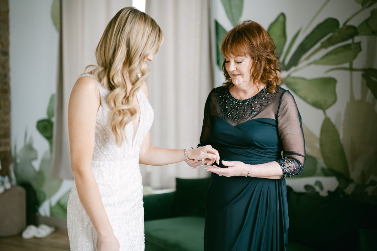 bride's mom puts on bracelet