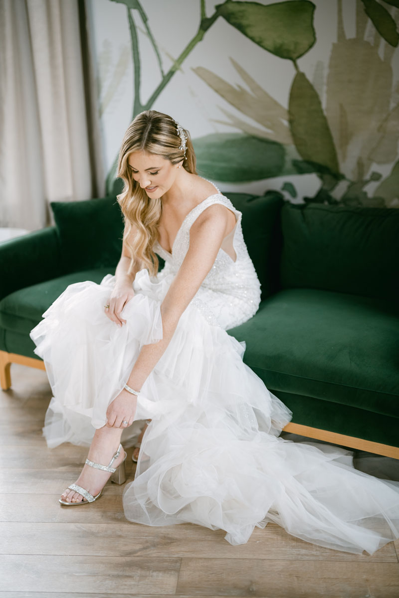 bride putting shoes on at walden wedding