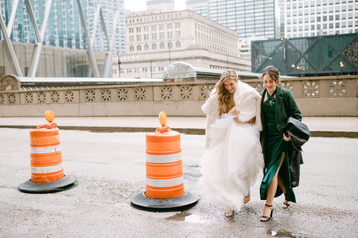 bride walking with bridesmaid on chicago winter wedding day