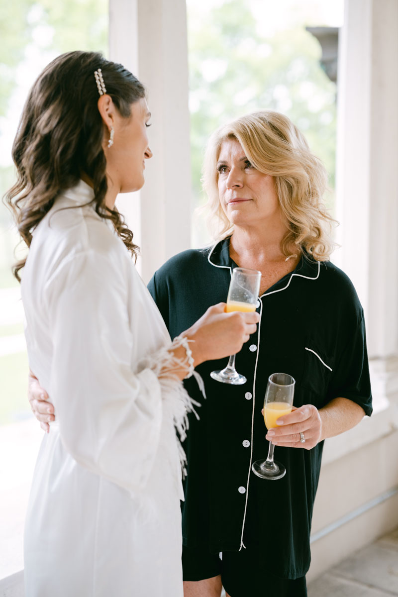 bride with her mom sipping champagne