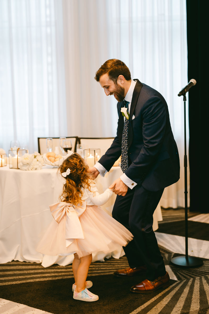 groom dancing with flower girl
