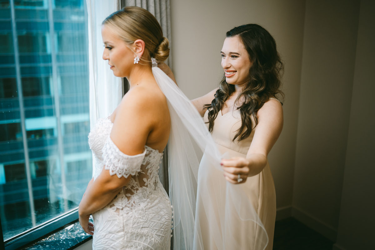bride getting ready with her bridesmaid