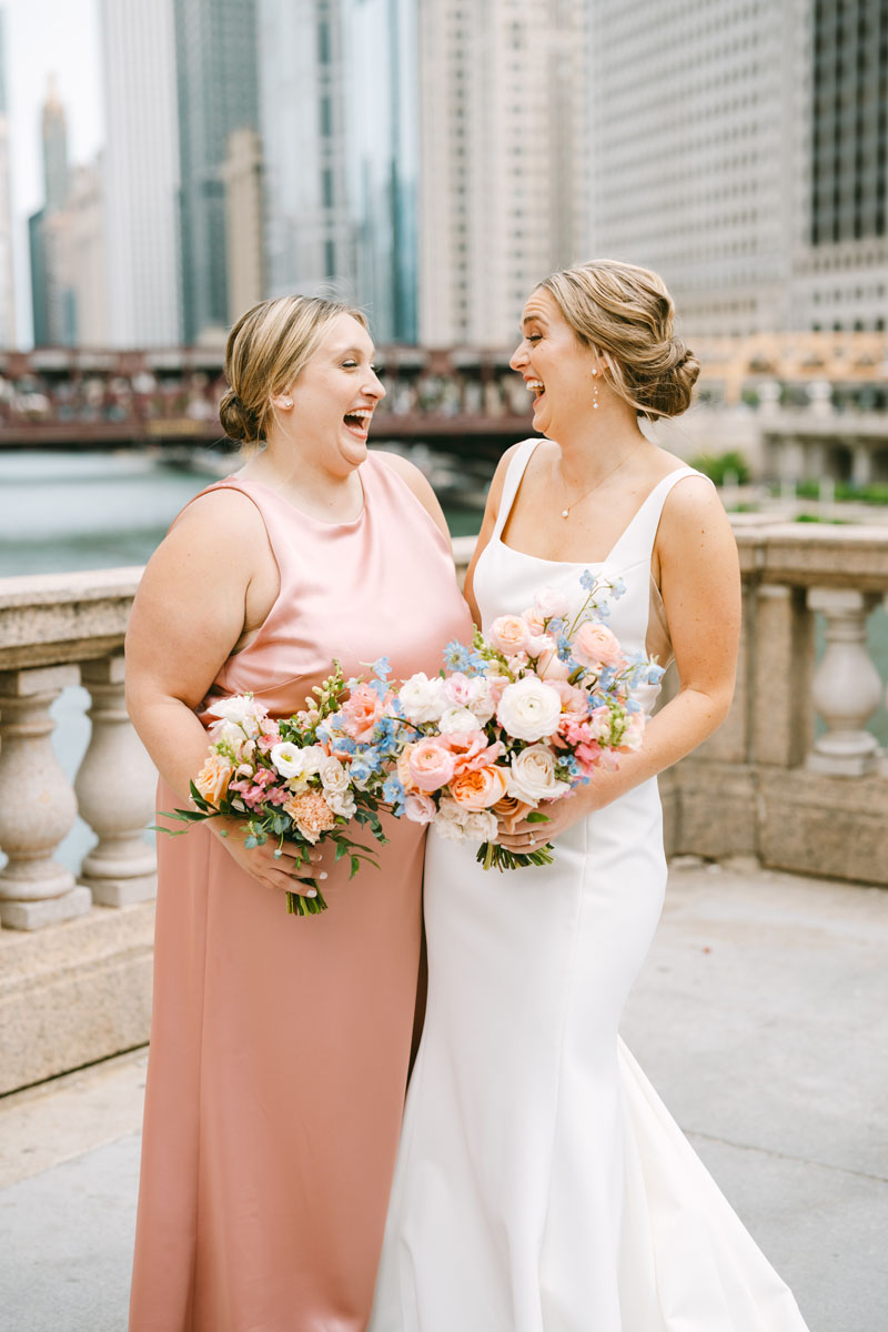 bridesmaid in blush dress laughing with bride